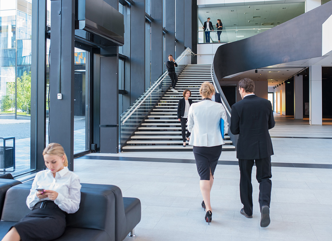 Insurance Solutions - Business Professionals Walking Through Modern Lobby